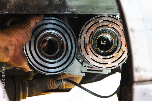 Картината върху платно Close-up comparing a new car air conditioning compressor clutch pulley with an old, rusted one during maintenance in an auto repair shop