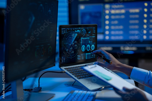 Fotografie Person working at a desk with a laptop showing a digital dashboard, dual monitor