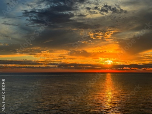 Photography Sunset dramatic sky clouds over dark calm ocean