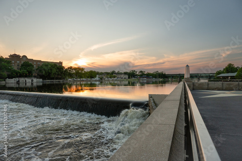 Obraz na płótnie Water flowing over a river dam at sunset