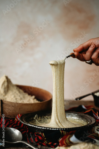 Stretching hot gooey Turkish kuymak from a bowl