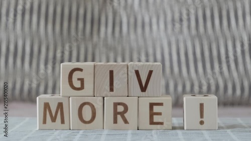 Give more!, laying out  by hand from letters on wooden cubes, slow motion
