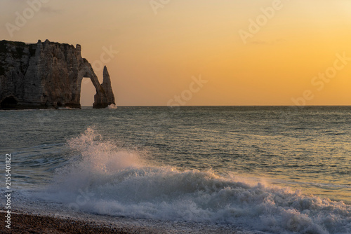 Konstfotografi Scenic sunset over the pebble beach in Etretat, Normandy, France, featuring the famous Porte d'Aval chalk cliff arch and Needle rock