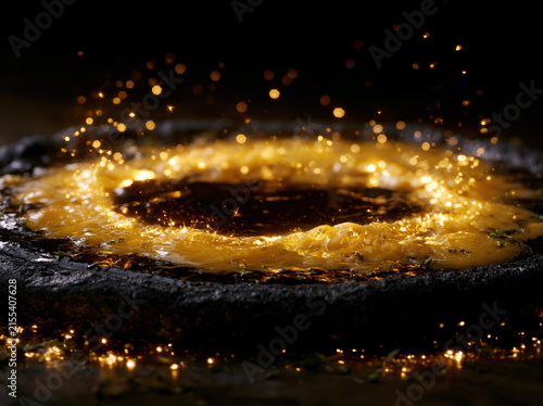 A black pizza resembling a solar eclipse, molten golden cheese forming the corona, charcoal crust, glowing herbs, cinematic food photography.