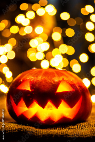 Vertical portrait of a scary Halloween jack o lantern glowing at night