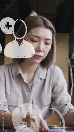 Animation of media icons over asian businesswoman holding document