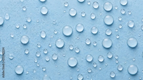 Clear water droplets on a textured light blue surface