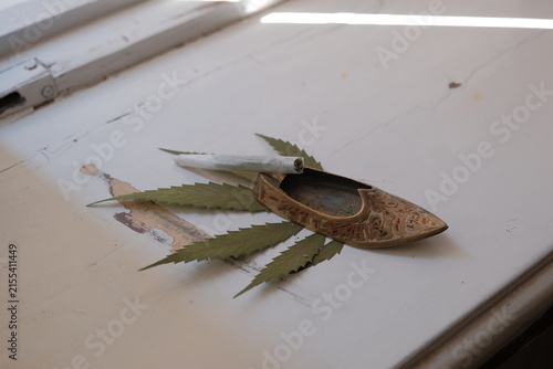 cannabis (hemp) roll-up. hand rolled on the background of dried classic cannabis (hemp) leaf