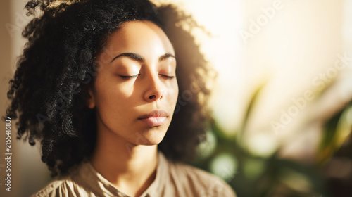 A serene person in a meditation pose with soft light and a clean, blurred background.