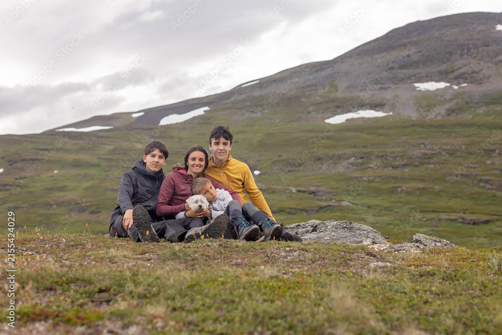 Fototapeta premium European family with children and pet dog, hiking Gorsabrua, the deepest canyon in Nortern Europe, with beautiful waterfall and bridge