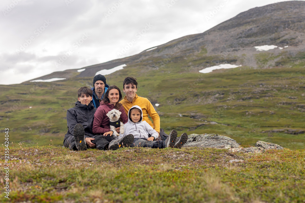 Fototapeta premium European family with children and pet dog, hiking Gorsabrua, the deepest canyon in Nortern Europe, with beautiful waterfall and bridge