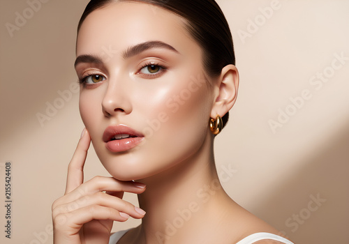 Portrait of a young woman with radiant skin and golden hoop earrings