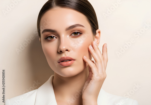 Elegant woman with healthy glowing skin touching her face