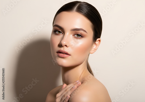 Beautiful young woman with glowing skin and professional makeup