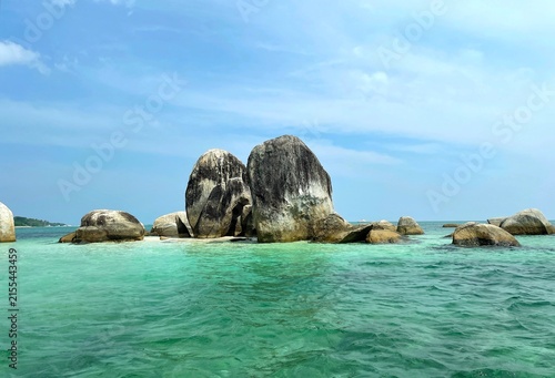 Foto Massive granite rock formations rise from the crystal-clear turquoise waters of the Belitung Sea on the route to Lengkuas Island, Indonesia