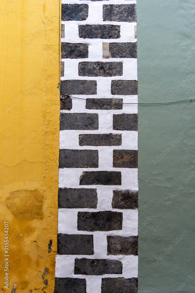 Fototapeta premium Colorful yellow green wall with white brick column