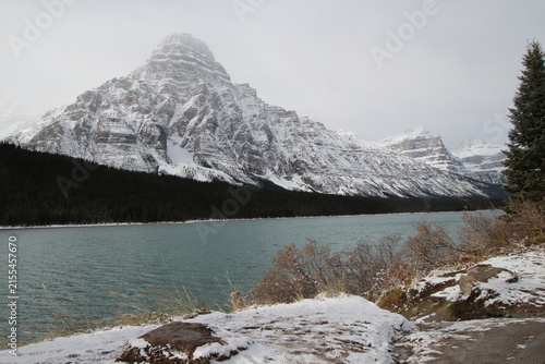 Historic Num Ti Jah Lodge on turquoise Bow Lake in Banff National Park, Alberta, Canada. Scenic mountain resort, red roof lodge, reflection, rocky mountains, sunny summer travel destination view.