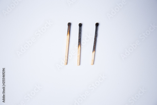Three used, burnt matchsticks against a white background