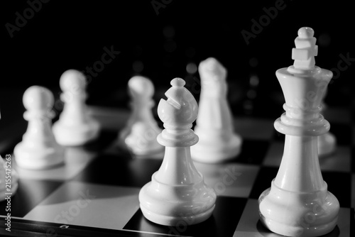 Foto Dramatic closeup of white chess pieces on black and white board with shallow dep