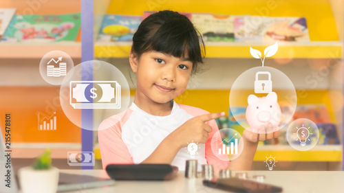 Asian girl pointing at piggy bank with financial icon overlay for digital banking and investment concept