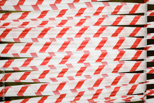 Obraz na płótnie Dense red and white safety tape forming a repetitive barrier pattern, suggesting