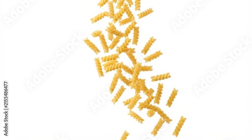Uncooked fusilli pasta pieces falling against white background