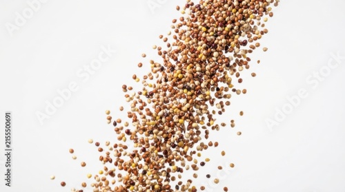 Sorghum grains falling against neutral background