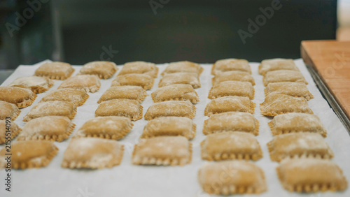 Fotografía Freshly made vegan pumpkin tortellini arranged in rows on a baking sheet