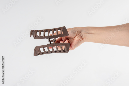 Cuadro en lienzo Brown doff color hairpin and hand isolated on white background