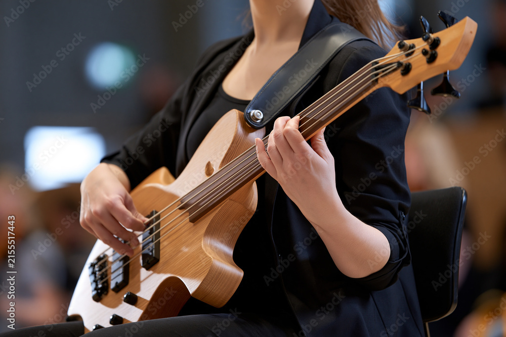 Fototapeta premium Musician plays bass at city hall concert