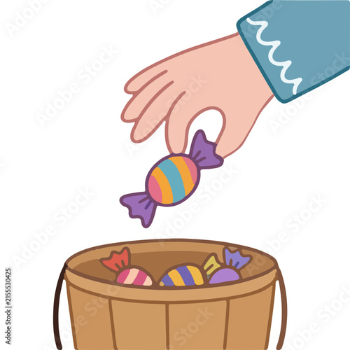 Hand Putting Candy In Halloween Trick Or Treat Basket