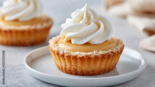 Lemon tart with whipped cream topping on white plate, delicious dessert close up
