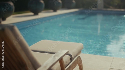 Luxury pool lounge chair near a swimming pool and manicured garden