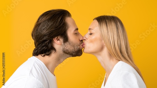 Cuadro en lienzo Happy Couple, Young Adult Males And Females, Kissing And Smiling Together Against Bright Yellow Background, Celebrating Love And Affection In A Joyful Moment, Lifestyle Concept