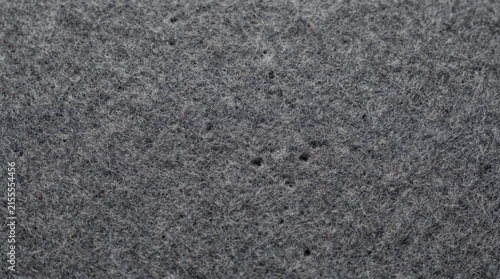 Dark grey felt texture displays a fine porous surface for design backgrounds.