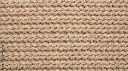 Knitwear pattern crafted from light beige yarn shows uniform vertical stitches.