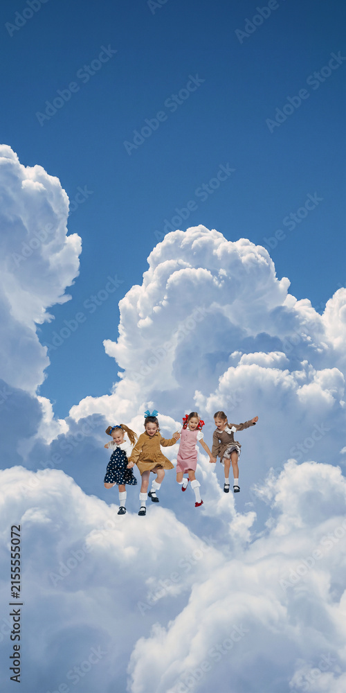 Fototapeta premium Group of children exploring soft cloud island high in blue sky. Concept of friendship, group discovery, curiosity, cooperative learning and educational projects.