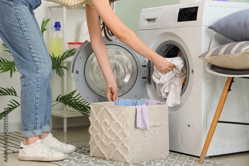 фотографія Young woman doing laundry in room