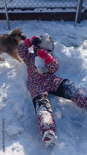 Child and dog. Child playing with snow in winter, part of a series
