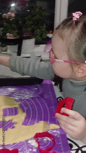 A child makes cookies from dough using cookie cutters