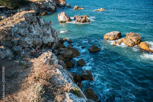 Scenic rocky coastline with turquoise sea water, cliff and rocks on a sunny day