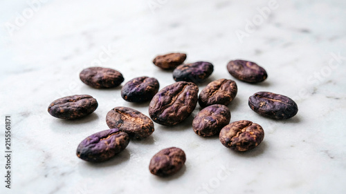 Raw Cacao Nibs on White Marble Macro