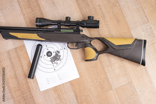 фотографія Top View of Scoped Sport Rifle with Ammunition Pellets and Paper Target