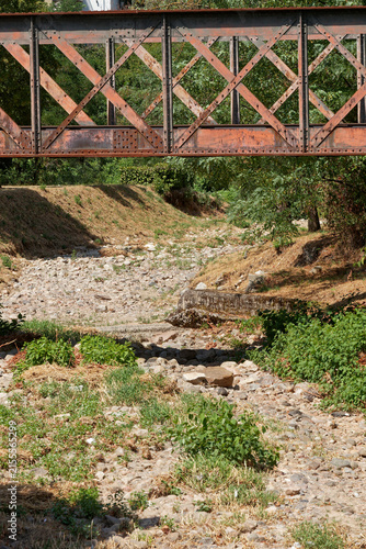 rivière tarie sous un pont métallique à cause de la canicule