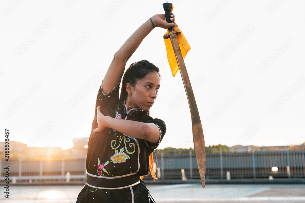 Fototapeta premium Chinese young woman practicing wushu kung fu.