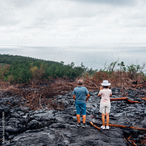 Couple de touristes sur une coulée de lave à l'île de La Réunion. Visiter les coulées de lave. Touristes à La Réunion. Vacances sous les Tropiques.