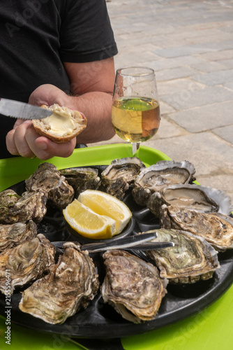 Pairing fresh oysters with Loire Muscadet white crisp, mineral wine; seaside tradition of family growers, simple and communal seaside dining in Saint-Malo, Brittany, Cancale oysters, France