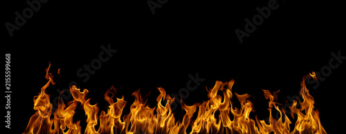 Realistic orange flames rising across a black background, creating a dramatic fire texture with dark copy space for energy, heat, danger, burning, special effects, and creative design.