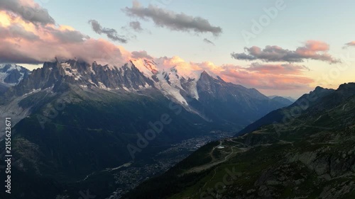 Mont Blanc Massif above Chamonix, Haute-Savoie, Auvergne-Rhone-Alpes, France, revealing alpine peaks, glaciers, the Chamonix Valley and mountain roads, drone oblique pullback.