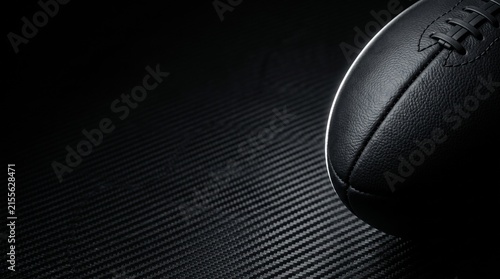 Black American football on dark textured background with copy space